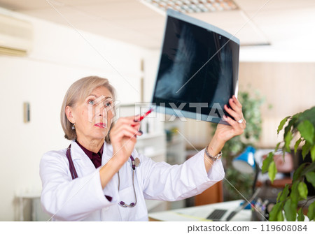 Female doctor examining x-ray at clinic 119608084