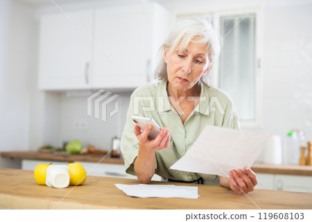 Senior woman analyzing bills at home Senior woman analyzing bills at home 119608103