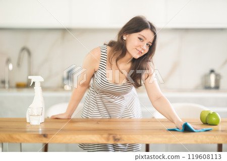 Young woman wiping table with rag 119608113