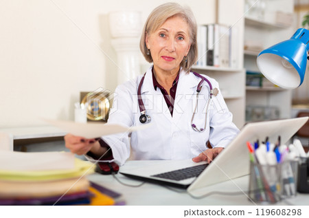 Aged female therapist handing out paper with prescriptions Aged female therapist handing out paper with prescriptions 119608298