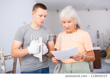 Grandmother and grandson are discussing the drawings of apartment room being renovated 119608325