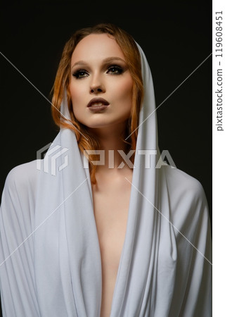 Woman in white fabric against a dark background, radiating elegance Woman in white fabric against a dark background, radiating elegance 119608451