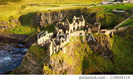 Dunluce Castle in Northern Ireland aerial view - Ancient Ruins Majestically Overlooking the Glorious Dunluce Castle in Northern Ireland aerial view - Ancient Ruins Majestically Overlooking the Glorious 119609114
