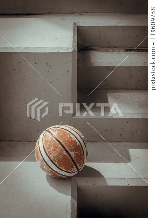 Old basketball ball on cement floor with Stairs leading and Natural light. Old basketball ball on cement floor with Stairs leading and Natural light. 119609238
