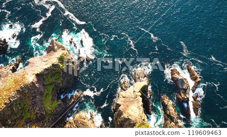 Stunning Aerial View of Vibrant Turquoise Waves Elegantly Crashing Against Rocky Shoreline Stunning Aerial View of Vibrant Turquoise Waves Elegantly Crashing Against Rocky Shoreline 119609463