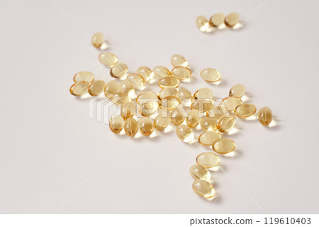 Scattered transparent capsules on white background highlighting health 119610403