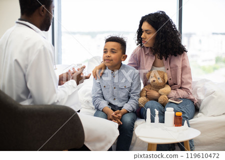 Young boy with mother consulted by doctor in hospital room 119610472