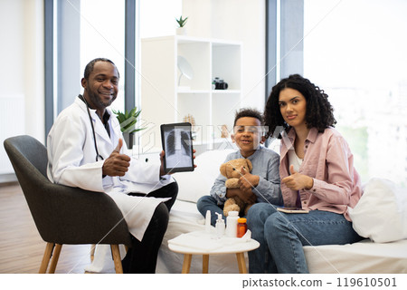 Doctor showing x-ray to happy child and parent in hospital 119610501