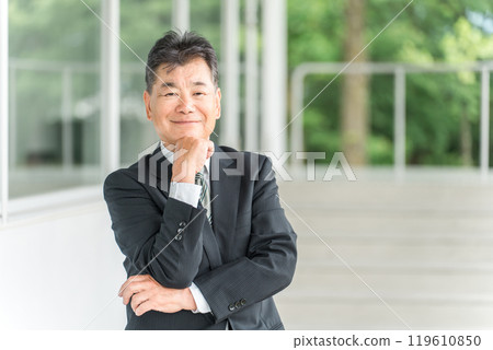 Senior male businessman resting his chin on his hands 119610850