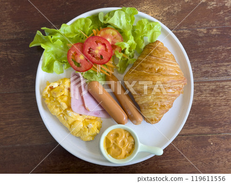 croissant with chicken sausage, ham, omelet and vegetables,tomato . The concept of breakfast croissant with chicken sausage, ham, omelet and vegetables,tomato . The concept of breakfast 119611556