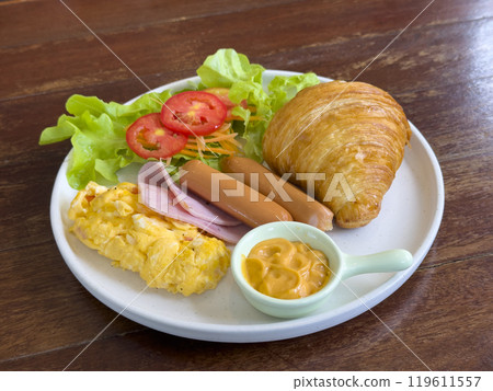 croissant with chicken sausage, ham, omelet and vegetables,tomato . The concept of breakfast croissant with chicken sausage, ham, omelet and vegetables,tomato . The concept of breakfast 119611557
