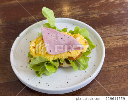 croissant with chicken sausage, ham, omelet and vegetables,tomato . The concept of breakfast 119611559