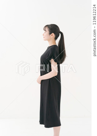 Portrait of a woman in her twenties wearing a black dress 119612214