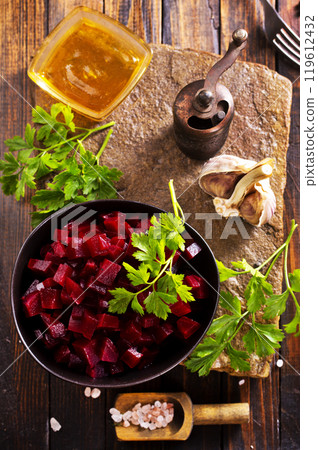 Plate of cut boiled beets with parsley on wooden table 119612432
