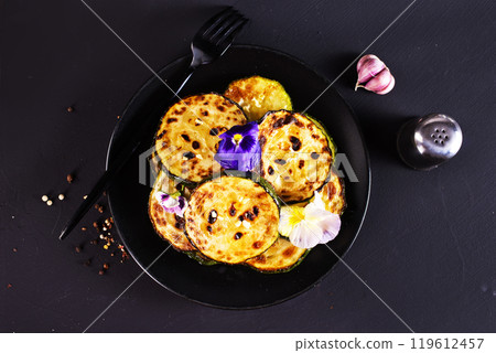 Heap of fried green zucchini and yellow vegetable marrows sliced into circles 119612457