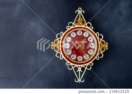 Old wall clock. Hands and Roman numerals on the dial. Old wall clock. Hands and Roman numerals on the dial. 119612529