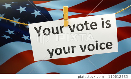 Hand hanging a sign that reads Your vote is your voice on the background of an American flag Hand hanging a sign that reads Your vote is your voice on the background of an American flag 119612583