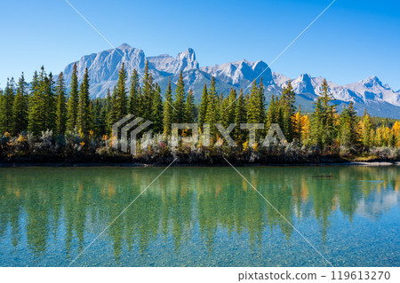 Canadian Rockies autumn landscape. Mount Rundle mountain range and trees reflected on the Bow River. Canmore, Alberta, Canada. 119613270