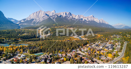 Aerial view of Town of Canmore downtown area in a autumn sunny day. Canadian Rockies mountain range in background. Alberta, Canada. Mount Rundle. 119613287