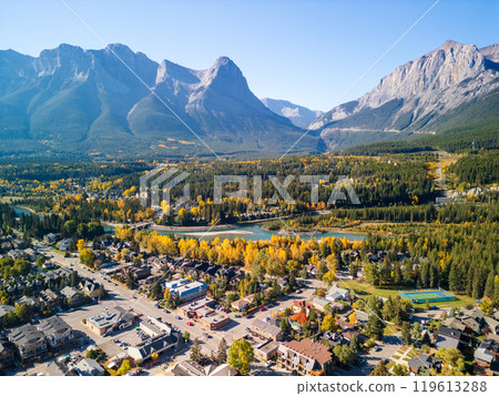 Aerial view of Town of Canmore downtown area in a autumn sunny day. Canadian Rockies mountain range in background. Alberta, Canada. 119613288