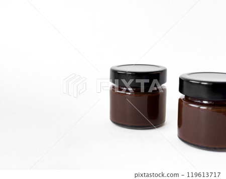 Minimalist composition of two chocolate spread jars on white background 119613717
