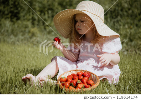 The Joyful Little Girl in a Straw Hat Enjoying The Joyful Little Girl in a Straw Hat Enjoying 119614174