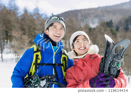 Couple enjoying snowshoes 119614414