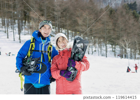 Couple enjoying snowshoes 119614415