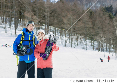 Couple enjoying snowshoes 119614416