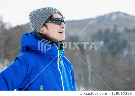 Man looking at snowy mountains Man looking at snowy mountains 119615356
