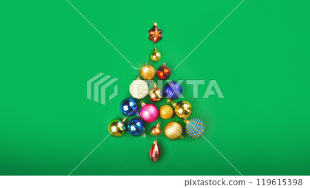 The Christmas tree is made of Christmas balls decoration. Minimum New Year concept on green background photo 119615398