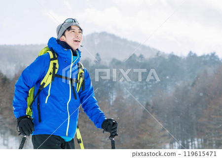 Man looking at snowy mountains 119615471
