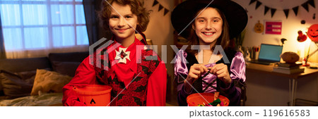Kids with treats in pumpkin buckets 119616583