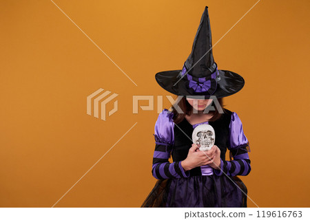 Girl looking at human skull in her hands Girl looking at human skull in her hands 119616763