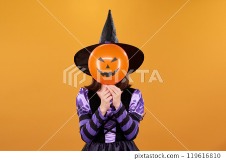 Halloween witch with pumpkin balloon 119616810