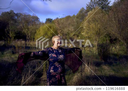 portrait of an elderly woman with gray hair in a dress and shawl in the autumn forest portrait of an elderly woman with gray hair in a dress and shawl in the autumn forest 119616888