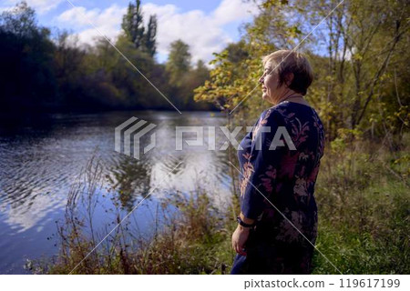 a portrait of an elderly woman with gray hair in a dress in the autumn forest a portrait of an elderly woman with gray hair in a dress in the autumn forest 119617199