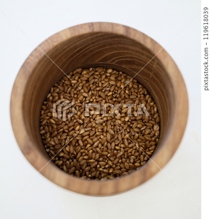 Wooden bowl filled with dried grains, minimalist rustic food photography with natural textures 119618039