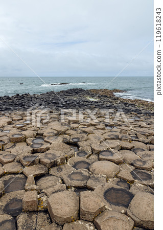 Vertical view of hexagonal basalt columns at Giant Causeway extending naturally into the Atlantic Vertical view of hexagonal basalt columns at Giant Causeway extending naturally into the Atlantic 119618243