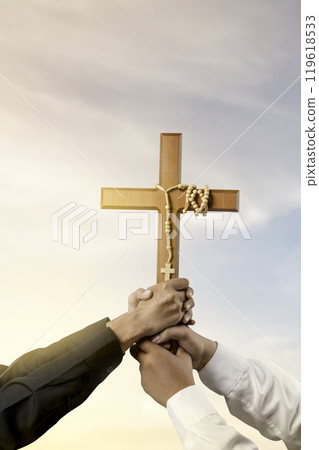 Man holding a religion cross with rosary beads together with sunlight background. Symbol of faith and worship in God. People christianity prayer Man holding a religion cross with rosary beads together with sunlight background. Symbol of faith and worship in God. People christianity prayer 119618533