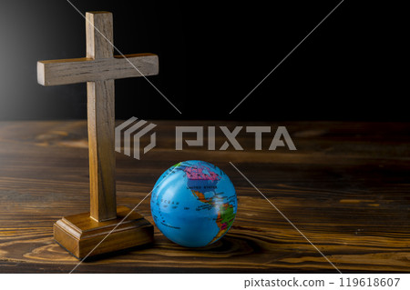 Religion christianity cross and globe on the table. Symbol of faith and worship in God Religion christianity cross and globe on the table. Symbol of faith and worship in God 119618607