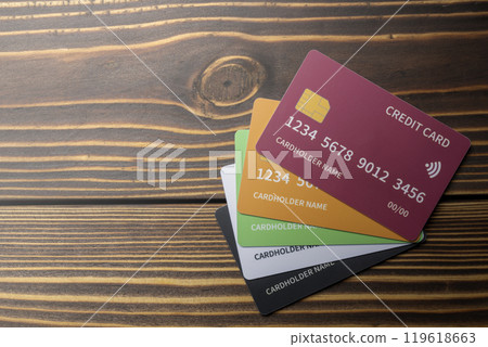 Top view of stack of debit or credit card on wooden background. The cards are of different colors 119618663