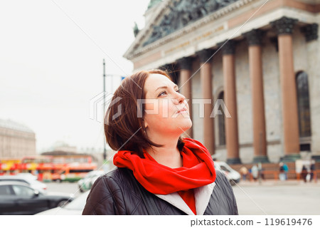 young caucasian woman looking up dreamily outside, portrait of city dweller 119619476