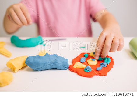 A child creates colorful shapes with play dough during an arts and crafts activity at home A child creates colorful shapes with play dough during an arts and crafts activity at home 119619771