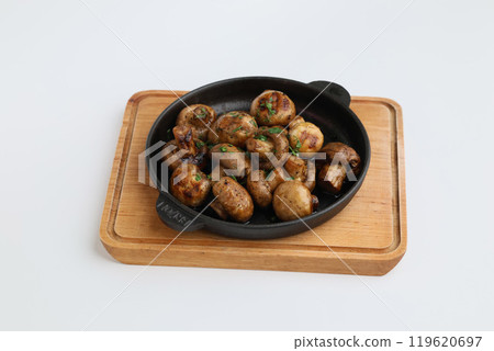 Grilled mushrooms with spices on a pan. Top view of brown champignon on pan on white background. Homemade food, healthy eating Grilled mushrooms with spices on a pan. Top view of brown champignon on pan on white background. Homemade food, healthy eating 119620697