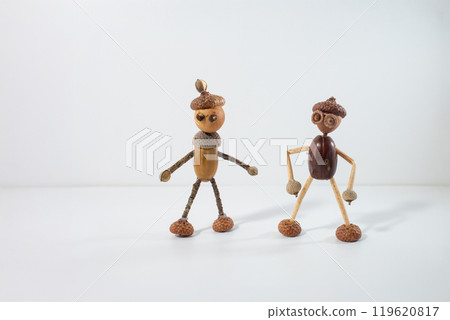 two charming figures crafted from acorns and sticks, arranged to resemble little humans. autumn craft activity for kids, 119620817
