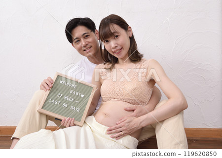 一位年輕的孕婦和她的丈夫擁抱 一位年輕的孕婦和她的丈夫擁抱 119620850