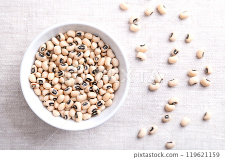 Dried black eyed peas in a white bowl over linen. Black eyed beans, or California blackeye, a legume of pale, medium-sized beans, with prominent black spot. Subspecies of cowpeas, Vigna unguiculata. 119621159