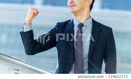 Smiling male businessman doing a fist pump 119622175