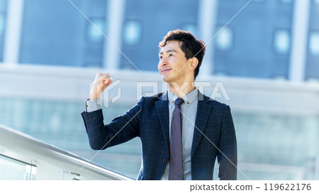 Smiling male businessman doing a fist pump 119622176